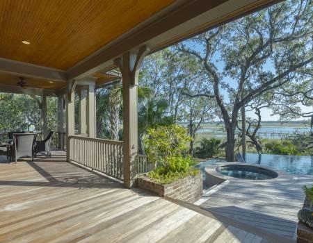 Wooden patio with view of hot tub and pool